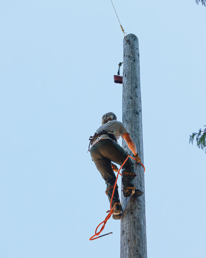 Contestants climb a 60-foot pole to show off their tree climbing abilities during the Amboy Territorial Days&rsquo; Log Show on Saturday, July 12.