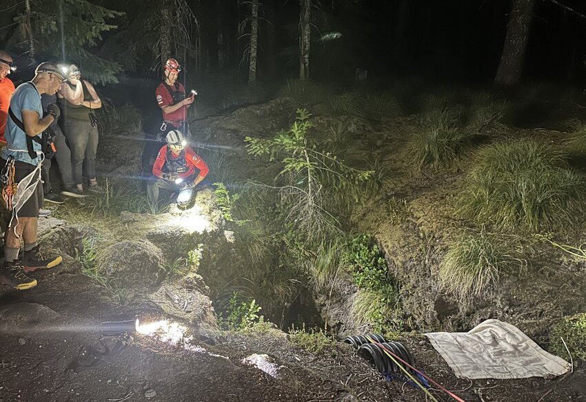 Volcano Rescue Team volunteers work to save a father and child at an opening to the Ape Cave south of Mount St. Helens on Wednesday, July 23, in this photo provided by the team.