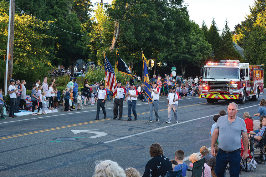 The local color guard leads the La Center Our Days Steamboat Celebration Twilight Parade down East Fourth Street on Friday, July 25. This year&rsquo;s procession drew a large crowd to kick off the renaissance-themed festivities.