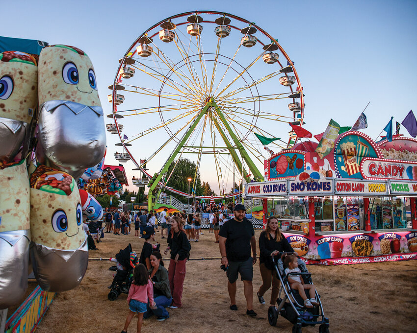 Families stroll through the carnival area as the crowds wind down on opening day of the 2025 Clark County Fair on Friday, Aug. 1.