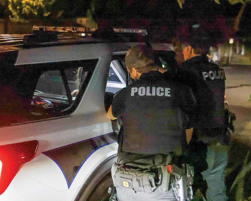 Ridgefield Police officers attempt to keep a female subject arrested for fourth-degree assault, domestic violence, and resisting arrest contained in the back of a patrol vehicle as she continuously resisted and utilized her legs and feet to keep the door open during a ride-along with the Ridgefield Police Department on Wednesday, July 30.