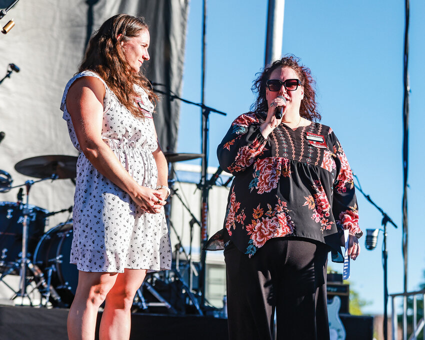 Clark County Food Bank Director of Development Rachel Beck, right, and Program Coordinator Murphy Best, speak to concertgoers on opening day of the Clark County Fair on Friday, Aug. 1, regarding a $5,000 donation from Fred Meyer to help the food bank&rsquo;s efforts.