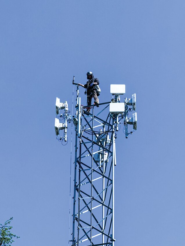 An Astound internet service technician is pictured installing fixed wireless network transmission devices atop an existing headend tower as the internet provider rolled out a new high-speed internet option to areas surrounding Woodland and elsewhere in Oregon and northwestern Washington earlier this month.