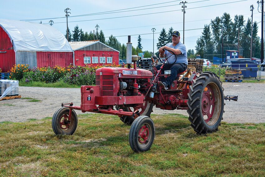 Joe Zimmerman, Finance and Marketing Director for Bi-Zi Farms, drives a 1952 tractor on the property. Zimmerman has worked to keep its festival traditions alive despite years of uncertainty over water rights.