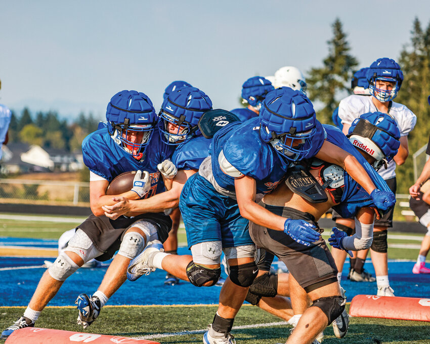 Ridgefield High School football players clash during drills in practice on Tuesday, August 26.