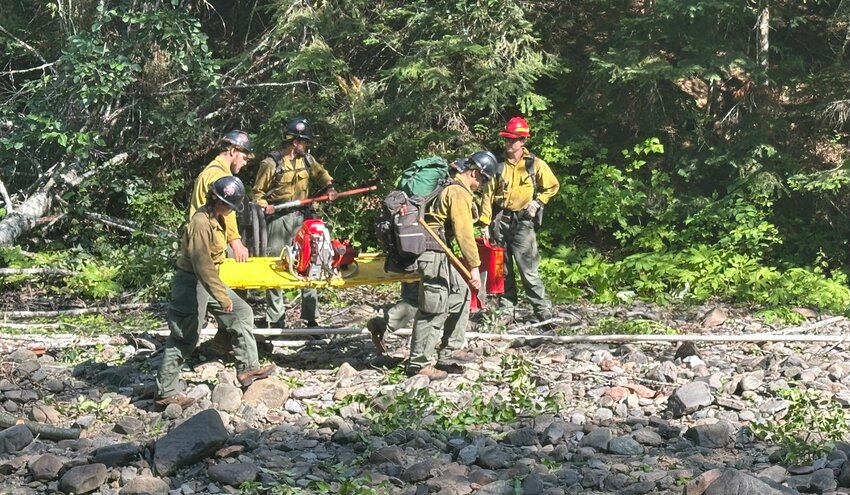 Devil's Ridge firefighters haul in a pump on the Hungry Fire. Firefighters on that fire have an extensive water system set up to utilize Elk Creek. Two miles of hose has been deployed.