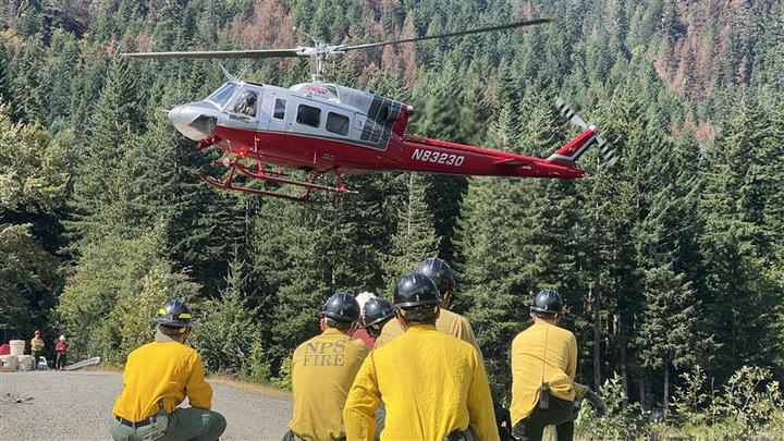 Wildland firefighters wait for a helicopter shuttle while battling the Bear Gulch fire in Washington state. (Photo by Bear Gulch Fire 2025 via Facebook)