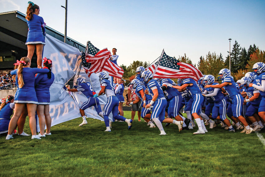 La Center football players run through their banner ahead of their 20-19 loss against Montesano High School on Friday, Sept. 5.