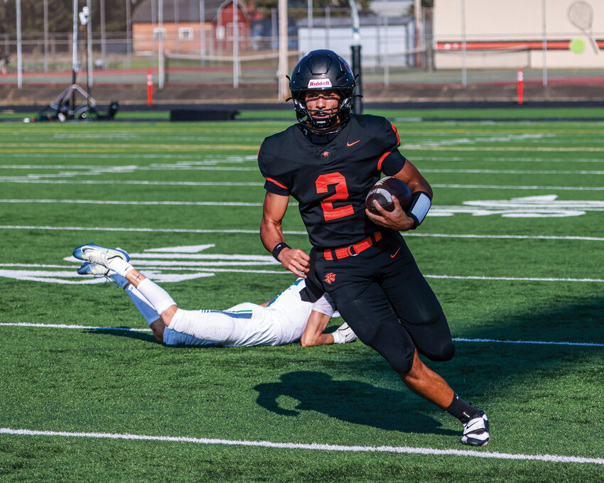 Battle Ground quarterback Ethan Adams blows by a Mountain View defender for a positive gain in the Tigers&rsquo; 48-7 win over the Mountain View Thunder on Friday, Sept. 12.