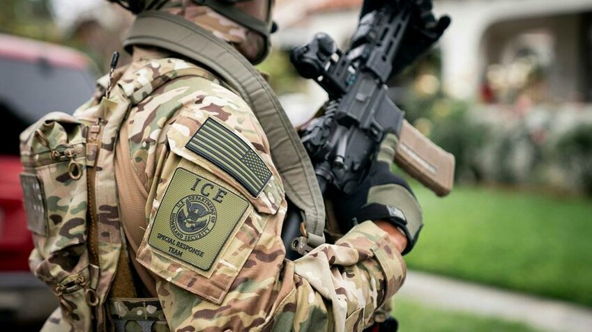 A U.S. Immigration and Customs Enforcement (ICE) Special Response Team (SRT) officer in full tactical gear stands alert during an enforcement operation in Los Angeles on June 12, 2025.
