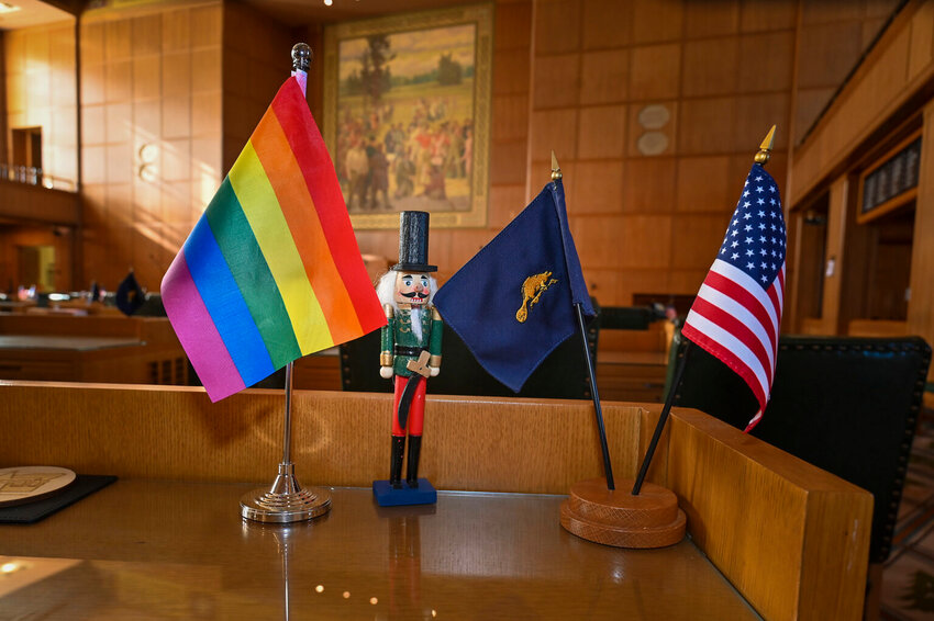 A Pride flag, Oregon flag and U.S. flag rest on a desk in the Oregon Capitol. The Trump administration on Tuesday notified Oregon of an investigation into a contested Oregon policy of requiring prospective adoptive and foster parents to affirm their child&rsquo;s gender identity. (Photo by Ron Cooper/Oregon Capital Chronicle)