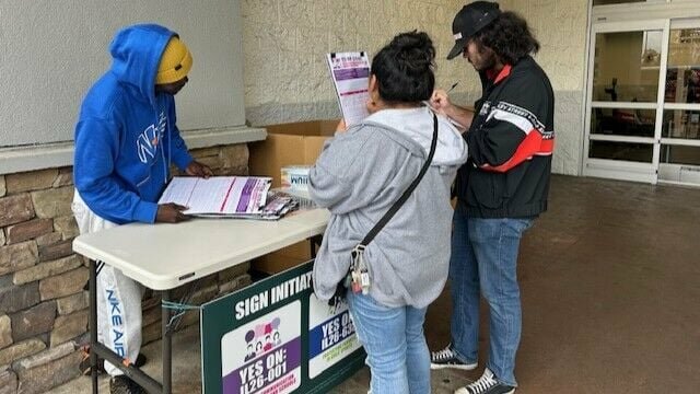 Signature gatherer and petition signers outside Walmart Supercenter in Federal Way on Oct 1, 2025.