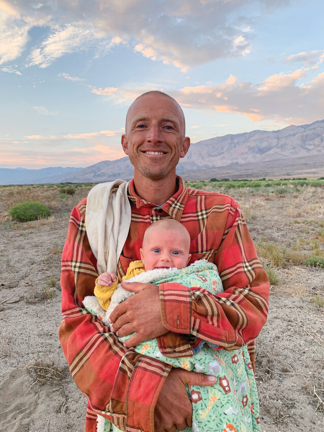 Soten Lynch holds his daughter, born June 25 in Mexico. Her arrival just weeks before his run has shaped how he balances fatherhood with his pilgrimage. Soten began a 1,400-mile run from the southern U.S. border to Battle Ground in August to raise support for Bells Mountain Dharma Center.