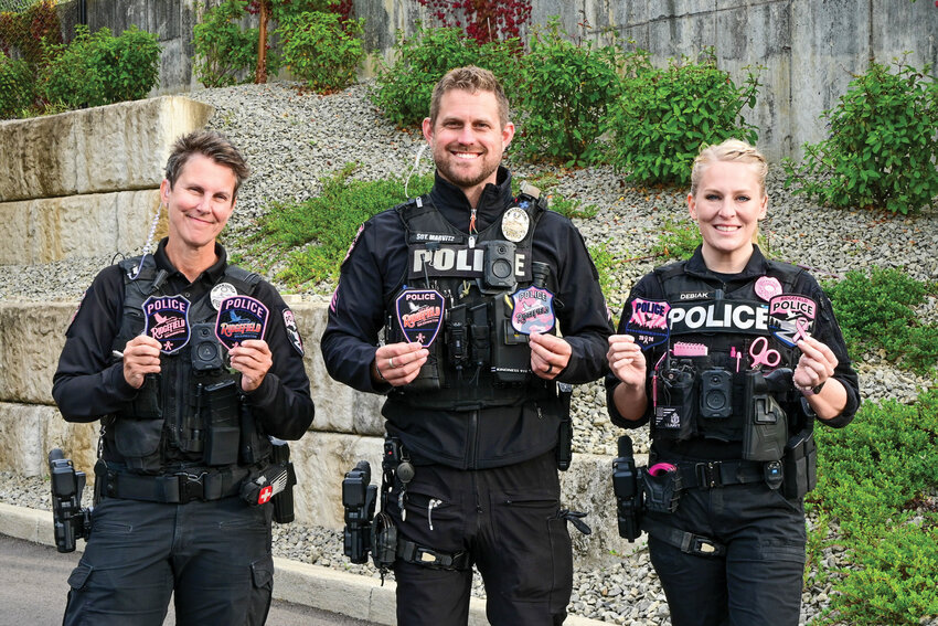 Ridgefield police officers hold up pink patches from past campaigns alongside the newly released 2025 badge, far right. The annual project has raised awareness and funds for breast cancer in Ridgefield since 2018.