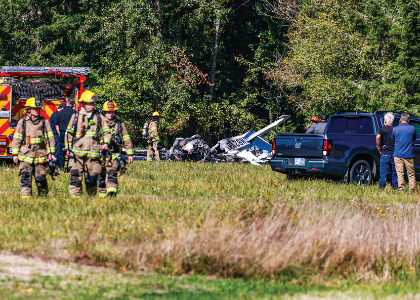 First responders walk away from a small plane that crashed and was fully engulfed in flames shortly after 1 p.m., Friday, Sept. 26, at Goheen Airport, a public use airfield with a grass runway north of Battle Ground.