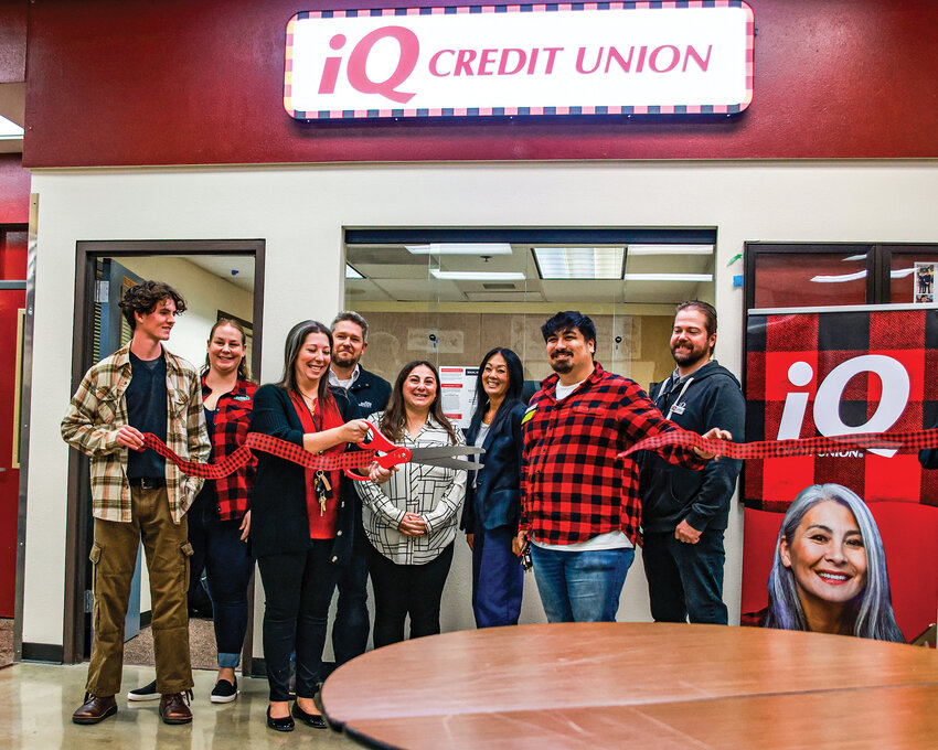 Prairie High School teacher Jenn Engelbart, with scissors, cuts the ribbon officially opening the IQ Credit Union student-run campus branch at Prairie High School on Tuesday, Oct. 14.