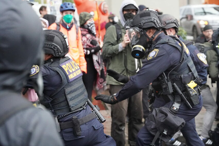 Department of Homeland Security police, along with other federal police, push protestors at the Immigration and Customs Enforcement facility south of downtown Portland on Sunday, Oct. 12, 2025. (Photo by Alex Baumhardt/Oregon Capital Chronicle)