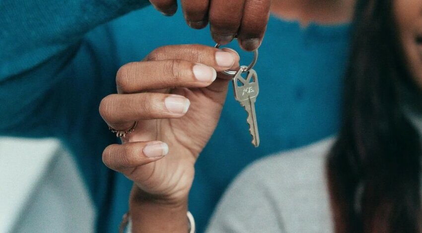 Couple holding a house key together.