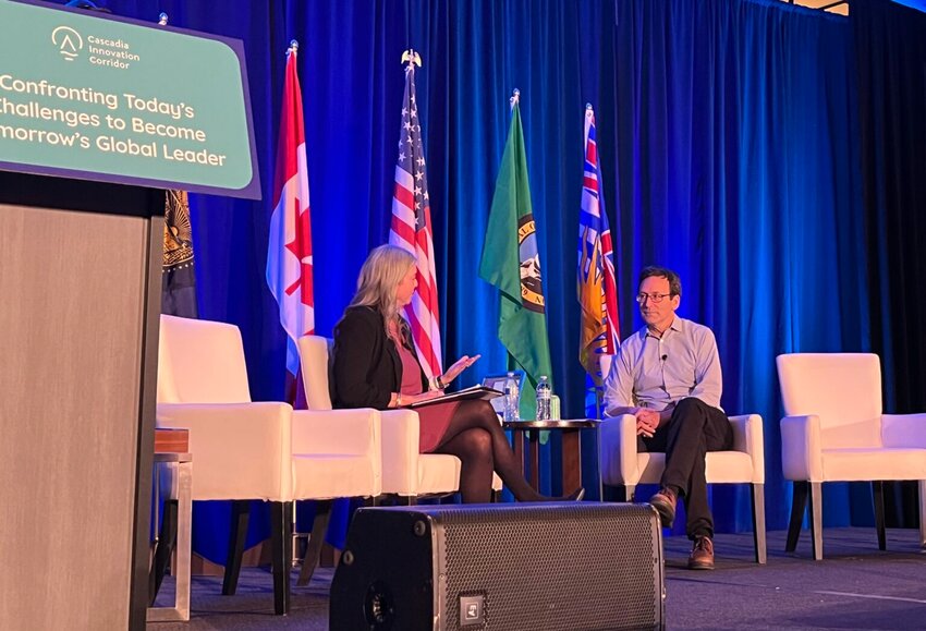 Washington Gov. Bob Ferguson speaks with Rachel Smith, president of the Washington Roundtable, during the Cascadia Innovation Corridor conference in Seattle, on Oct. 29, 2025. (Photo by Bill Lucia/Washington State Standard)