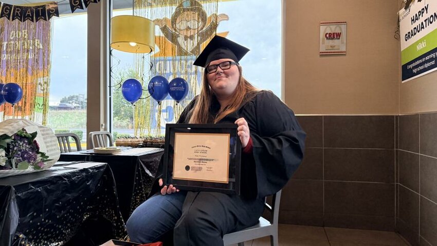 Nikki Thompson, a crew trainer who works at the Kelso McDonald's, holds the diploma she earned through the company's "Archways to Opportunity" program during a special graduation ceremony Thursday, Oct. 30, in the restaurant lobby.