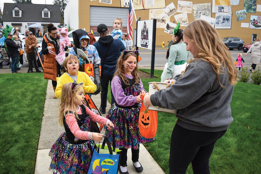 A Dev&rsquo;s Coffee Bar employee hands out candy to families passing by during the Trick-or-Treat Trail. Local businesses welcomed trick-or-treaters all afternoon.