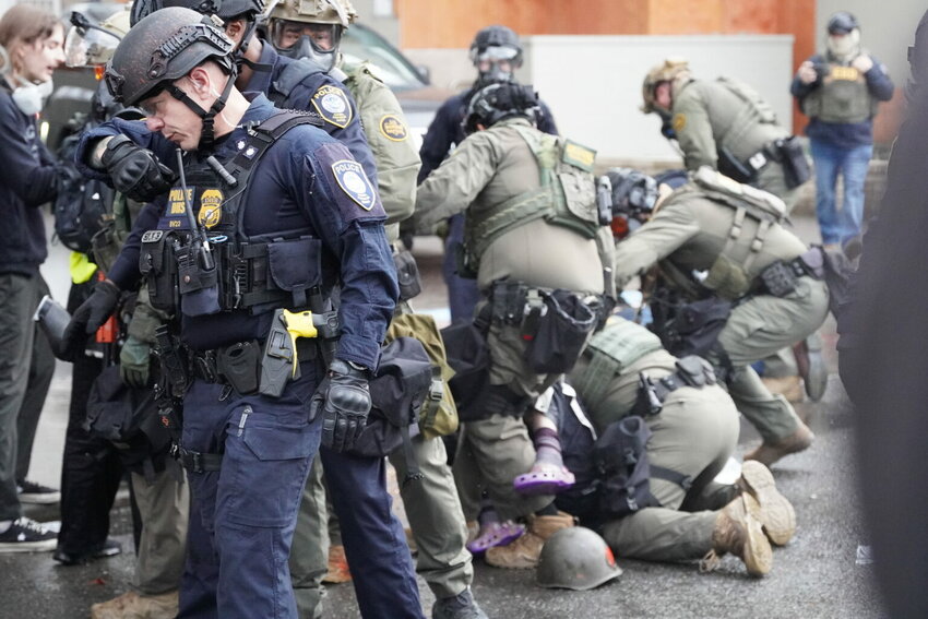 Department of Homeland Security police, along with other federal police, push and tackle protesters at the Immigration and Customs Enforcement facility south of downtown Portland on Sunday, Oct. 12, 2025. (Photo by Alex Baumhardt/Oregon Capital Chronicle)