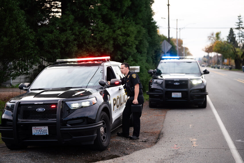 Centralia police officers discuss a collision involving a man driving a box truck and a parked vehicle on the 2100 block of North Pearl Street in Centralia on Wednesday, Nov. 12.