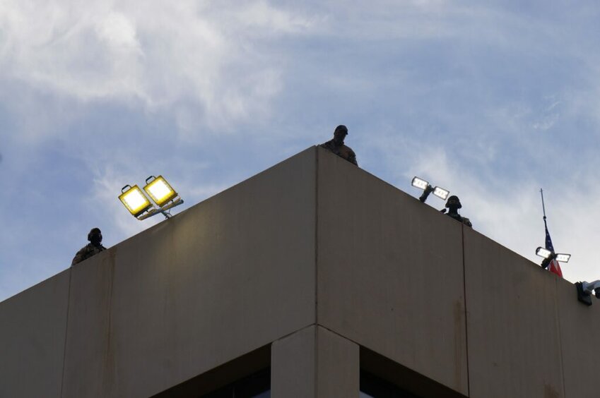 Federal officers atop the ICE building in Portland on Sunday, Sept. 28, 2025.