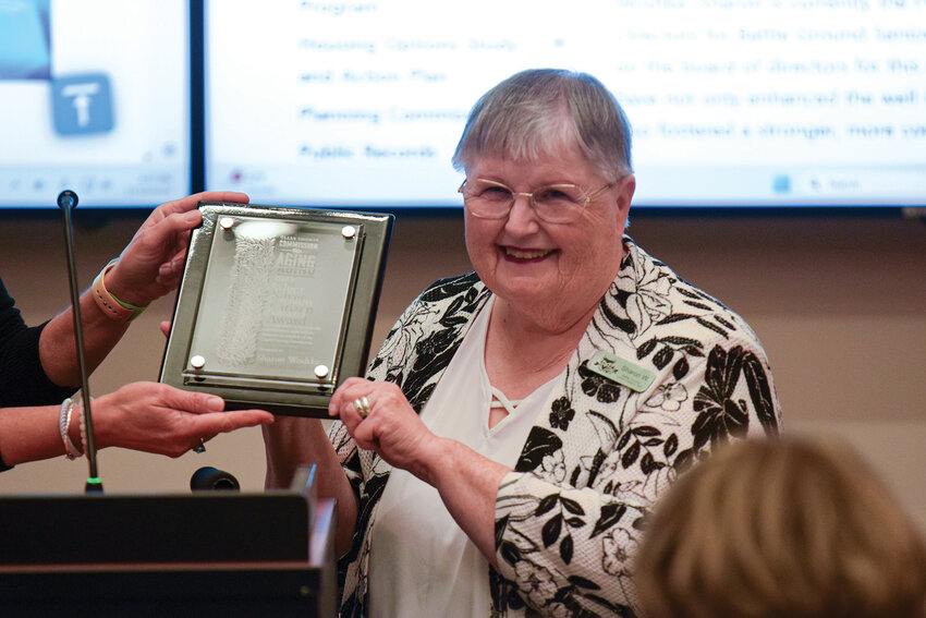 Battle Ground Senior Citizens Inc. President Sharon Wodtke speaks to attendees while holding the Silver Citizen Award on Nov. 19. She was honored for her leadership in helping revive the group after the COVID-19 pandemic.