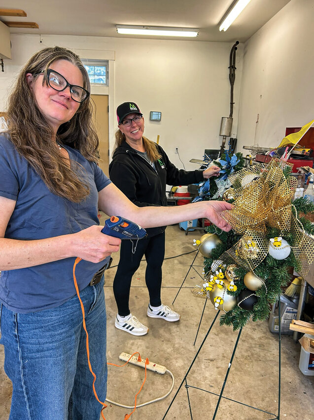 Battle Ground Rotary Club members Amy Price and Saundra Kamman decorate wreaths that will be available in the rotary&rsquo;s Festival of Wreaths and Wine online auction beginning Dec. 2 and running through Dec. 6.