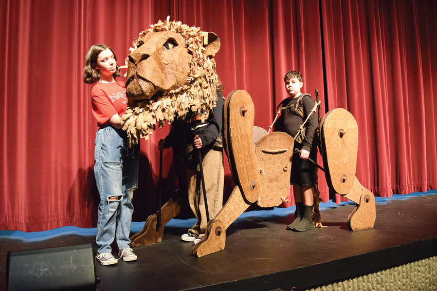 Clara Wigginton, Sophia Crawford and Shane McColm operate the Aslan puppet during a rehearsal at the Washburn Performing Arts Center during a Saturday, Nov. 29, rehearsal. Journey Theater&rsquo;s &ldquo;Narnia&rdquo; musical opens Dec. 5, with six performances across two weekends.