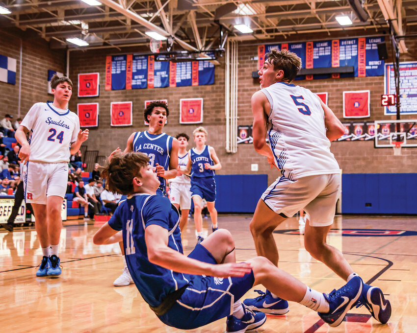 Ridgefield senior Jamison McCann, No. 5, goes up for a basket after knocking La Center freshman Brody Mills to the floor in Ridgefield&rsquo;s 71-57 win on Wednesday, Dec. 3.