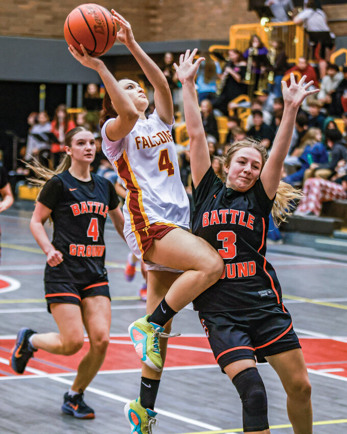 Prairie&rsquo;s Ashdyn Southard, no. 4, goes for a contested lay-up guarded by Battle Ground defender Lilah Smithline in the Falcons&rsquo; 60-26 win over the Tigers on Tuesday, Dec. 2.
