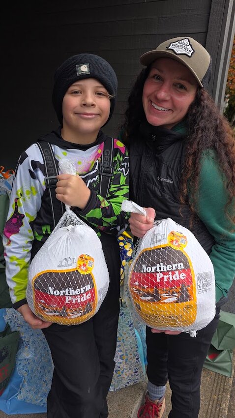 Ridgefield Lion Ariana Dronen and her son, Atreyu Dronen, pack turkeys at the Compassion 360 Thanksgiving food box event.