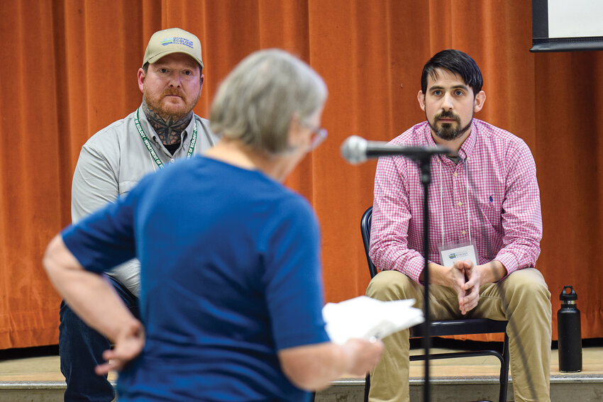 Ann Shaw asks a question to Michael Cronin and Forrest Malone of the Department of Ecology during a Wednesday public update at Hockinson Middle School. The meeting focused on the cleanup of Camp Bonneville.