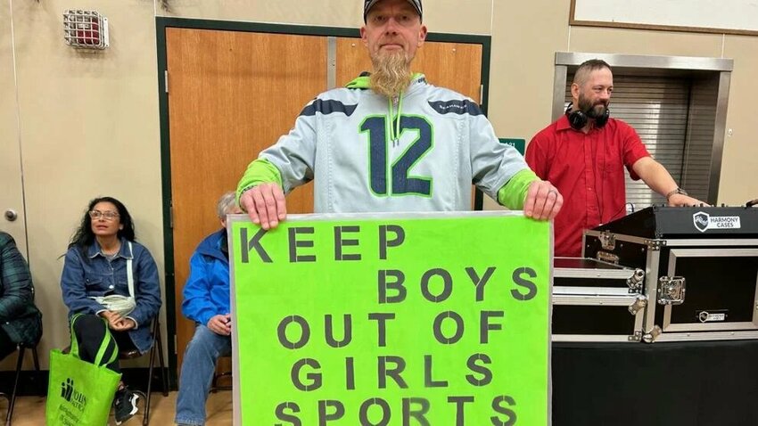 A rally attendee carrying a sign in support of a statewide initiative to protect girls in sports by keeping biological males out.
