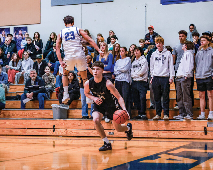 La Center junior forward Duane McWoods flies right by Woodland junior wing Michael Belvin during the Woodland Beavers&rsquo; 66-39 win over La Center High School on Friday, Jan. 2.