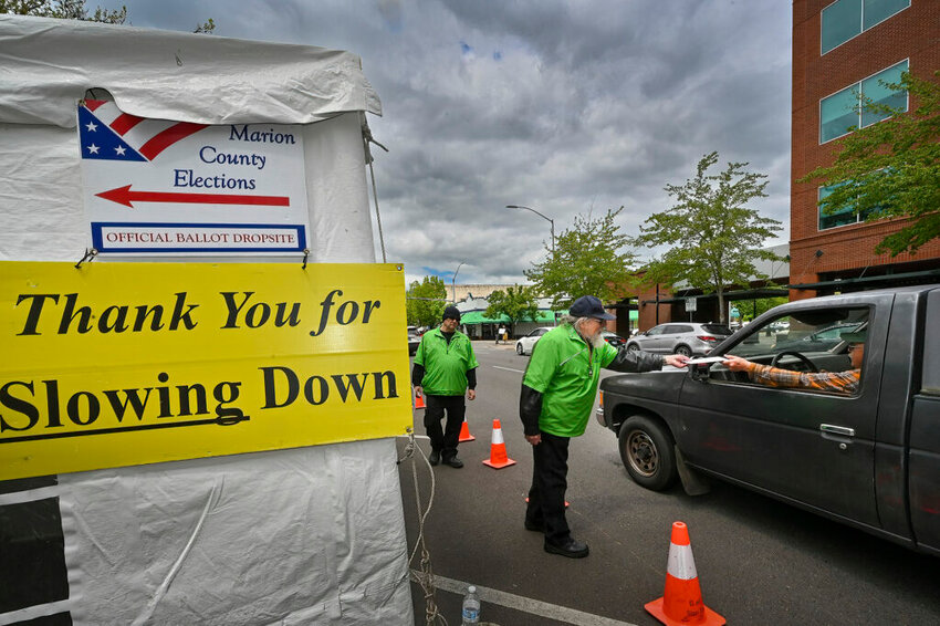 Jeff Ogg receives a ballot on Monday, May 16, 2022, at a drive-up Marion County ballot drop site in Salem. (Photo by Ron Cooper/Oregon Capital Chronicle)