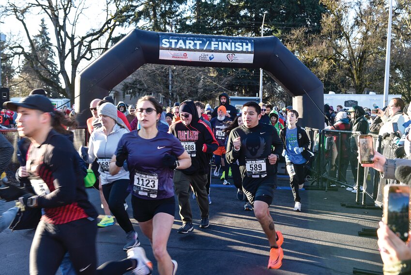 Runners burst off the starting line of the 10K race at the 11th annual Race For Warmth in 2024 at Fort Vancouver Way in Vancouver.