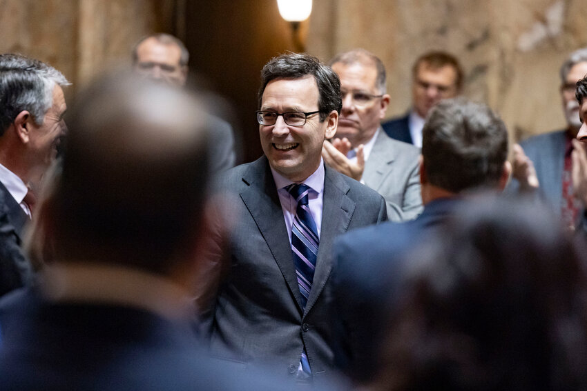 Gov. Bob Ferguson greets legislators before delivering the State of the State address in Olympia on Tuesday, Jan. 13.