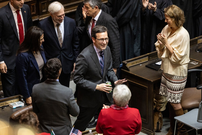 Gov. Bob Ferguson greets legislators as he leaves the House chamber in Olympia on Tuesday, Jan. 13.