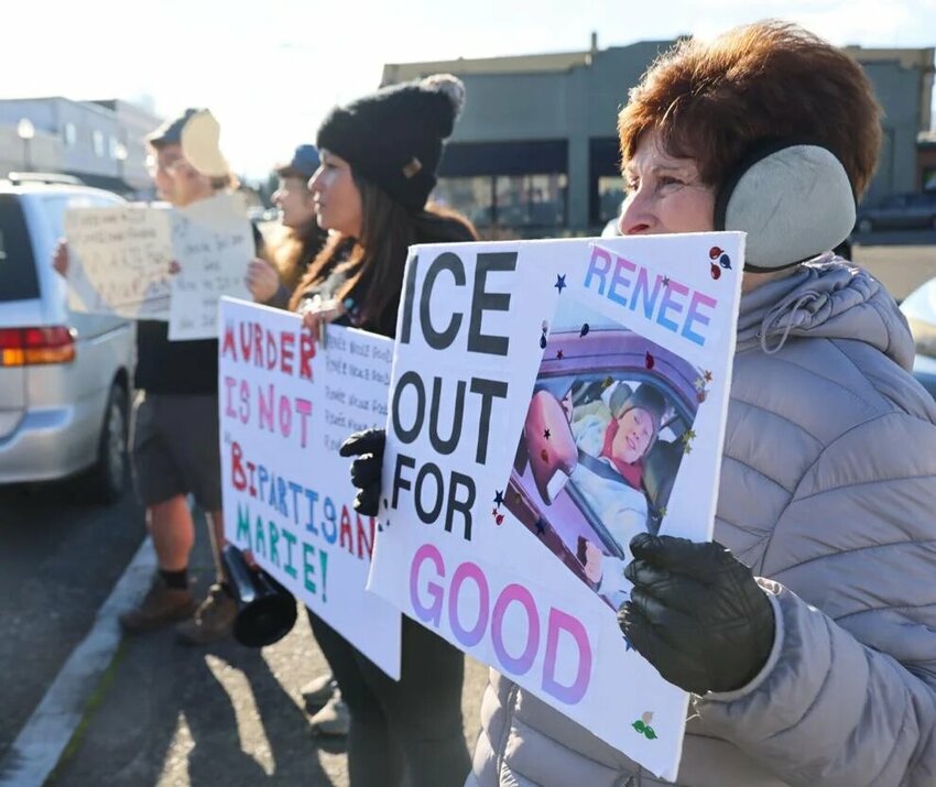Vickie Reif, 77, of Kelso and on the far right, holds a sign with a photo of Renee Good on Thursday, Jan. 15 outside the office of Rep. Marie Gluesenkamp Perez in Kelso. Good was fatally shot by an ICE officer last week in Minneapolis, but while the federal government says the killing was justified, protesters like Reif disagree.