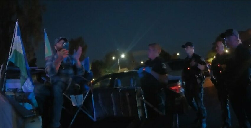 Jon-Erik Hughes Hegstad, 40, of Longview, sits on a camping chair in truck bed on Sept. 10 in Longview, before being arrested on suspicion of disorderly conduct and fourth-degree assault during a vigil for slain right-wing activist Charlie Kirk.