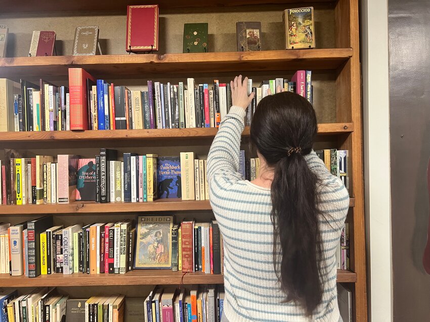 A staff member stocks shelves at the Literary Leftovers Used Bookstore in Battle Ground ahead of the shop&rsquo;s 25th anniversary celebration on Thursday, Jan. 29. The store will mark the milestone with an all-day sale and an evening community gathering.