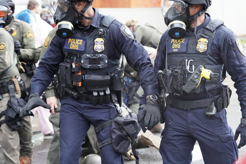 Department of Homeland Security police, along with other federal police, push and tackle protesters at the Immigration and Customs Enforcement facility south of downtown Portland on Sunday, Oct. 12, 2025. (Photo by Alex Baumhardt/Oregon Capital Chronicle)