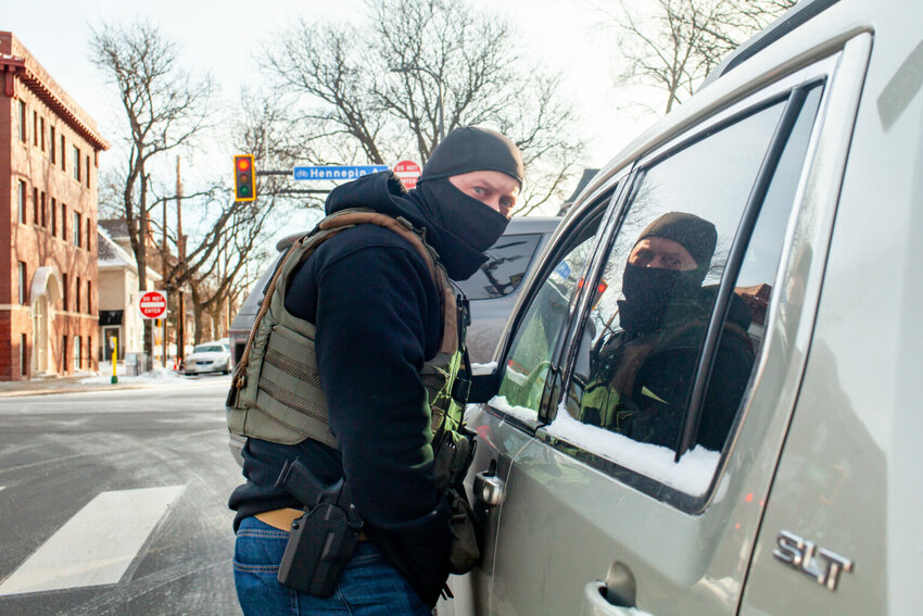 Federal agents block in and stop a woman to ask her for another person&rsquo;s whereabouts Monday, Jan. 19, 2026 in south Minneapolis. (Photo by Nicole Neri/Minnesota Reformer)