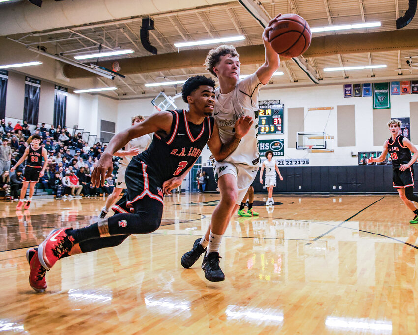 Woodland junior forward Tanner Cusick gets a hand on a loose ball while R.A. Long&rsquo;s Cam Newsome chases the ball in Woodland&rsquo;s 64-57 loss on Thursday, Jan. 29.