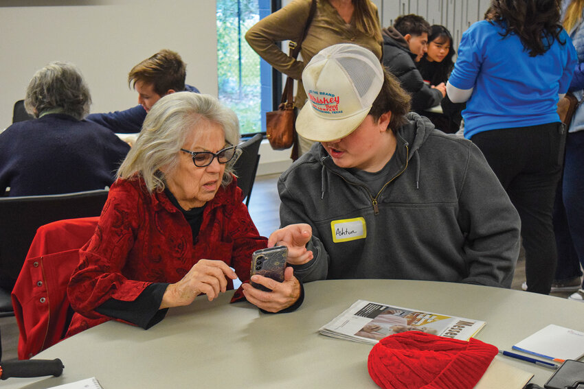 Battle Ground High School student Ashton Larson supports a senior during a cellphone class at the Battle Ground Senior Center on Monday, Jan. 26. Students from Battle Ground School District partnered with Battle Ground Senior Citizens Inc. to provide one-on-one help for seniors learning to use their phones.