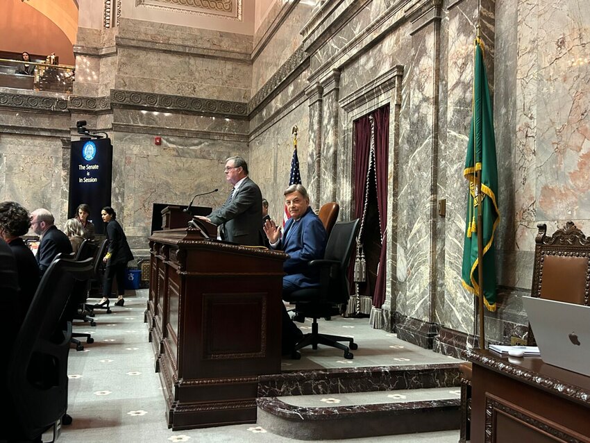 Longtime Mariners broadcaster Rick Rizzs waves to the Capitol press corps on the Washington state Senate floor as the team is honored Monday, Feb. 2, 2026. (Photo by Jake Goldstein-Street/Washington State Standard)