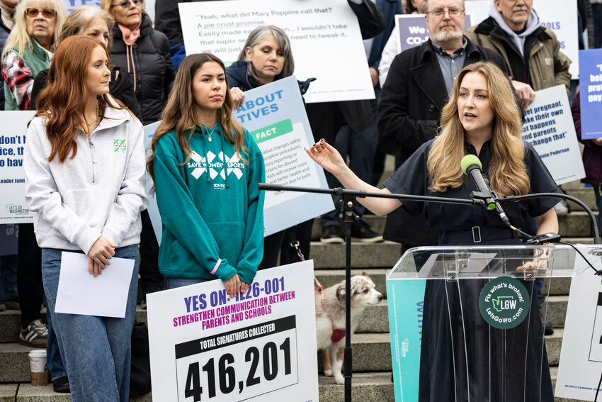 Podcaster Brandi Kruse introduces high school students Frances Staudt, of Tumwater High School, and Ahnaleigh Wilson, of Eastmont High School, at a Let&rsquo;s Go Washington rally supporting initiatives concerning parental rights and barring transgender athletes from participating in girls&rsquo; athletics at the Washington state Capitol on Tuesday, Feb. 3.